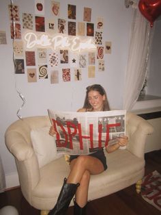 a woman sitting on a couch holding up a newspaper