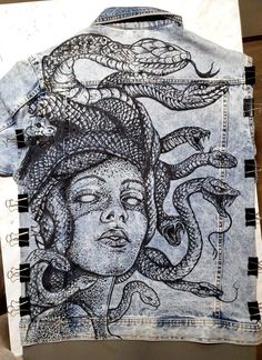 a denim jacket with an image of a woman and snakes on it