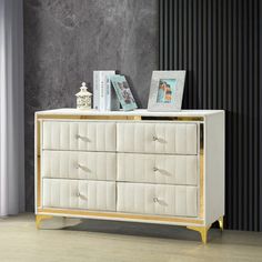 a white and gold dresser with pictures on top