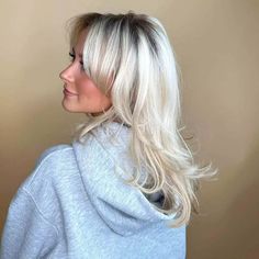 Unveil the charm of platinum blonde with a hint of depth at the roots, crafted into elegant, long layers for a full-bodied silhouette. Styled into a bouncy blowout with a curtain fringe that softly frames the face, it's a classic style with a modern flair. Intrigued? Click for more and follow us on Pinterest! ** Photo Credit: Instagram @hairbyellastenhaard Bouncy Blowout