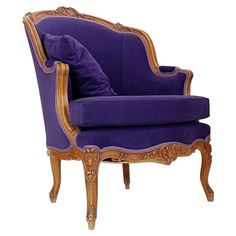 a purple chair with gold trimmings and a blue pillow on the armrest