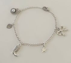 a silver bracelet with charms on it and a star, moon, heart, and shamrock