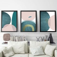 three framed art prints on the wall above a couch