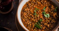 a bowl filled with beans and cilantro on top of a table