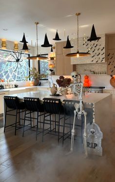 a skeleton statue sitting on top of a kitchen counter next to a table with chairs