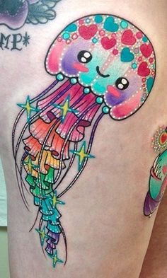 a woman's thigh with an octopus and jellyfish tattoo design on it,