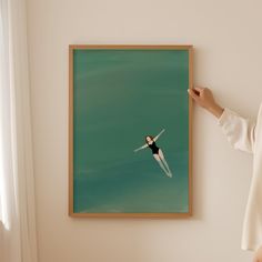 a woman standing in front of a painting on the wall