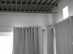 an empty room with white curtains and light coming through the window