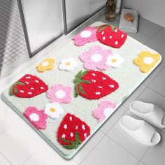 a bathroom rug with strawberries and flowers on it