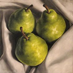 three green apples sitting on top of a white cloth