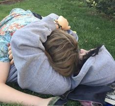 a person laying on the grass with a stuffed animal