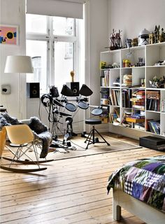 a bedroom with a bed, chair and musical equipment