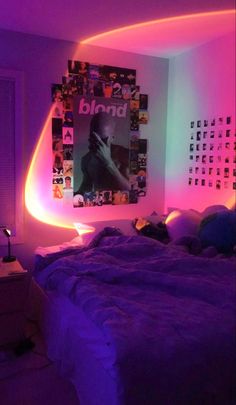 a bed with purple and green lights in a bedroom next to a painting on the wall