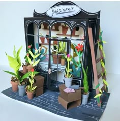 a paper model of a flower shop with potted plants