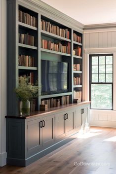 a living room with bookshelves and a television on the wall in front of it