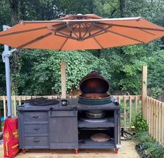 an outdoor grill with an umbrella over it