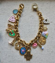 Each Antiqued Gold Charm bracelet is completely unique and handmade in our Texas studio. The one shown in the pictures is the one that you will receive. The chain is made of solid brass with an antique gold wash finish. It’s loaded with a mix of antique gold washed pewter, repurposed vintage and gold filled charms. The mix is the most fun part of making these- we love to mix charms that look vintage with enamel charms, lockets, gemstones and sparkle. Length: 7 1/4 inches Diy Charm, Stacked Necklaces, Gold Gemstone Ring, Repurposed Vintage, Gold Charm Bracelet, Bracelet Ideas, Gold Wash, Enamel Charms, Look Vintage