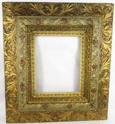 an ornate gold frame with flowers and vines on the edges, hanging from a wall