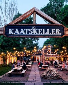 people sitting at picnic tables under a sign that says the kaatskiller