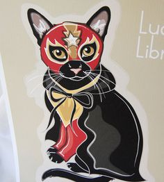 a black cat with a red mask on it's face sitting next to a sign that says lucky lion