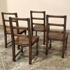 three wooden chairs sitting next to each other on a tile floor in front of a wall