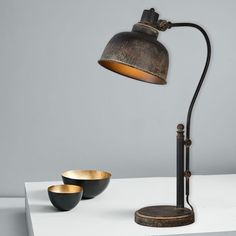 two bowls are sitting on a table next to a lamp that is turned on and off