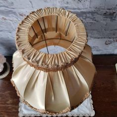 a gold colored vase sitting on top of a wooden table next to a cupcake