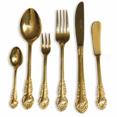 an assortment of gold colored utensils and spoons