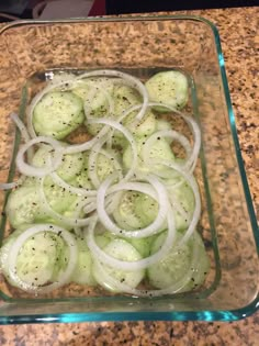 sliced cucumbers and onions in a glass dish