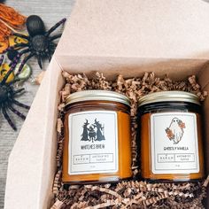 two jars of honey sitting in a box