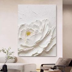 a living room filled with furniture and a large white flower on the wall above it