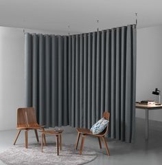 two chairs and a table in front of a curtained window with grey drapes