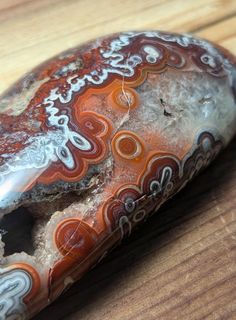 an orange and white rock sitting on top of a wooden table