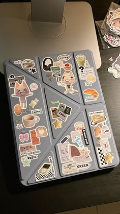 a laptop computer sitting on top of a desk covered in stickers