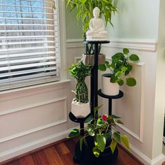 there are many plants in the corner of this room and one is on top of a stand