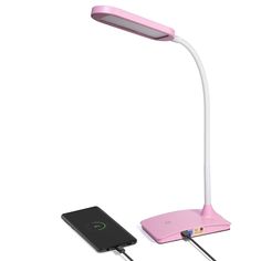 a pink desk lamp next to a charger on a white background with a black phone