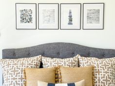 a bed with pillows and pictures on the wall above it