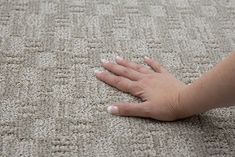 a person's hand is on the carpet