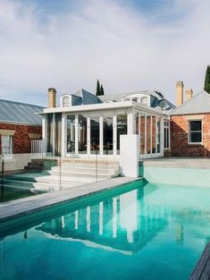 a house with a pool in front of it and some windows on the back wall