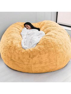 a woman is laying in a large bean bag chair