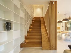 a woman sitting on a couch in front of a book shelf next to a stair case