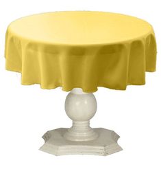 a yellow table cloth on top of a white cake stand with a round base and circular cover