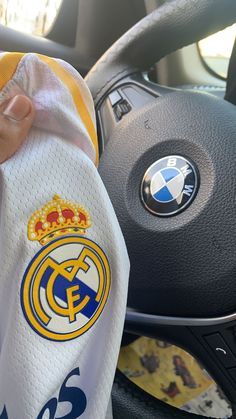 a person holding a towel in their hand while sitting in a car with the steering wheel behind them