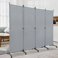 a room divider with wheels on each side in front of a couch and coffee table