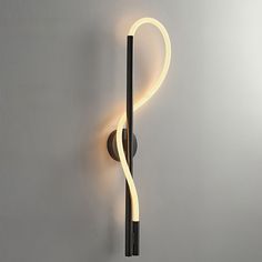 a black and white wall mounted light with a curved tube on it's side