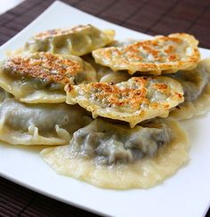 some dumplings are sitting on a white plate