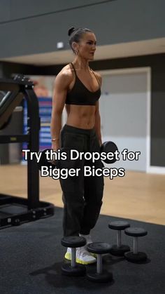 a woman standing in front of a gym machine with the words try this dropet for bigger biceps