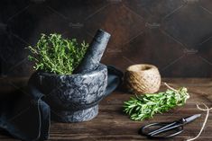 herbs in mortar bowl and scissors on wooden table