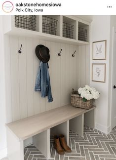 a coat rack with hats and coats on it next to a bench in a hallway