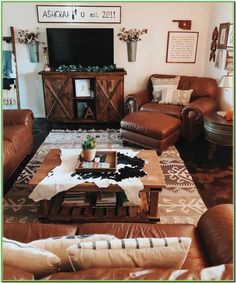 a living room filled with brown leather furniture and a flat screen tv mounted to the wall